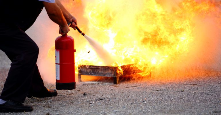 Man puts out fire with extinguisher.